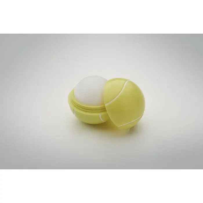 Balsam de buze in forma de minge de tenis de culoare galbena cu interior alb si recipient din plastic