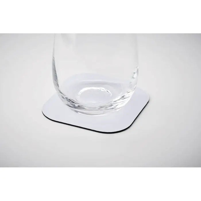 Coaster de sublimare pătrat alb cu margine neagră din material rezistent sub un pahar transparent