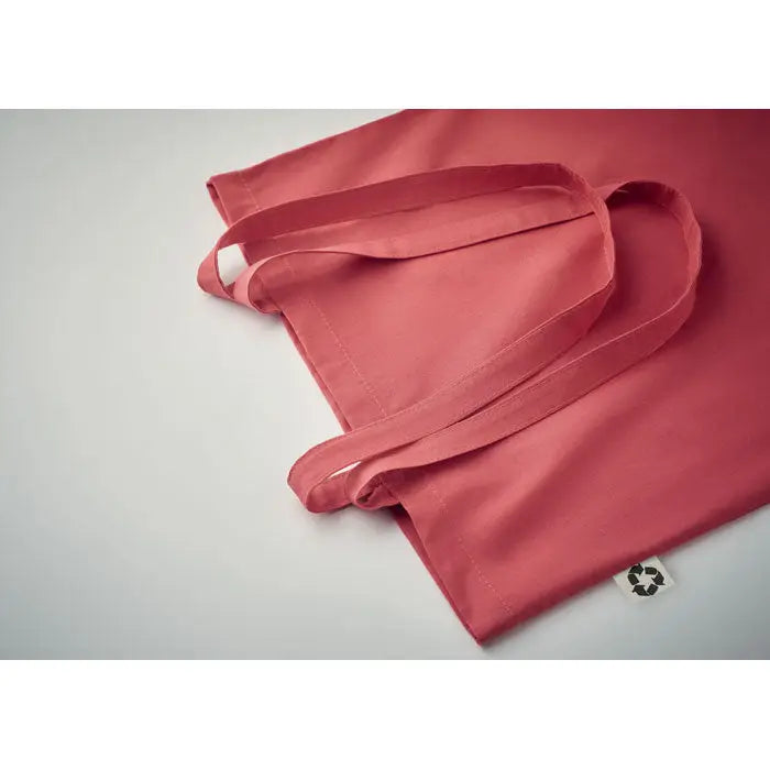 Geanta de cumparaturi din bumbac reciclat in nuanta coral cu manere din material textil si eticheta mica reciclatã