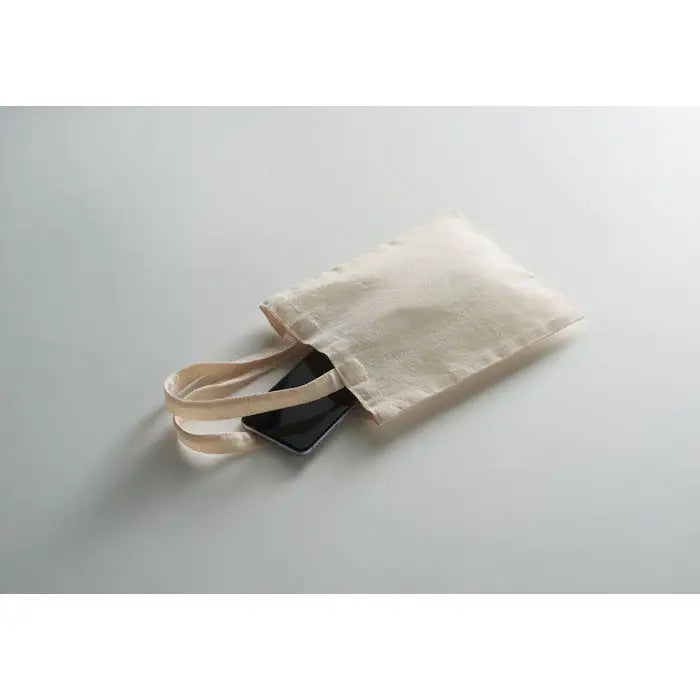 Geanta mica cadou din bumbac 140 gr/m² bej cu doua manere, deschisa partial, cu telefon negru inauntru