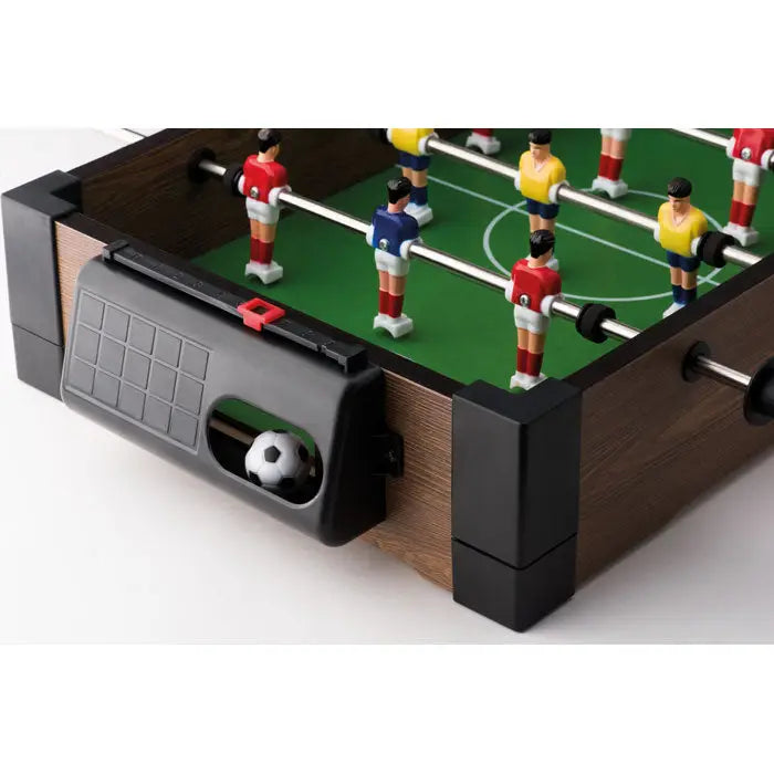Mini fotbal de masa din lemn maro cu componente negre, teren verde si jucatori rosii, galbeni si albastri