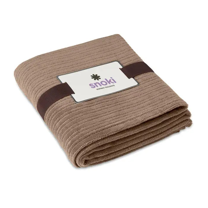 Patura de lana 240 gr/m2 din material moale taupe cu textura in dungi si panglica maro inchis care fixeaza eticheta