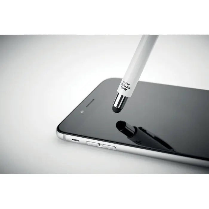 Pix cu stilou antibacterian alb cu vârf metalic și text negru pe corp, așezat lângă un smartphone