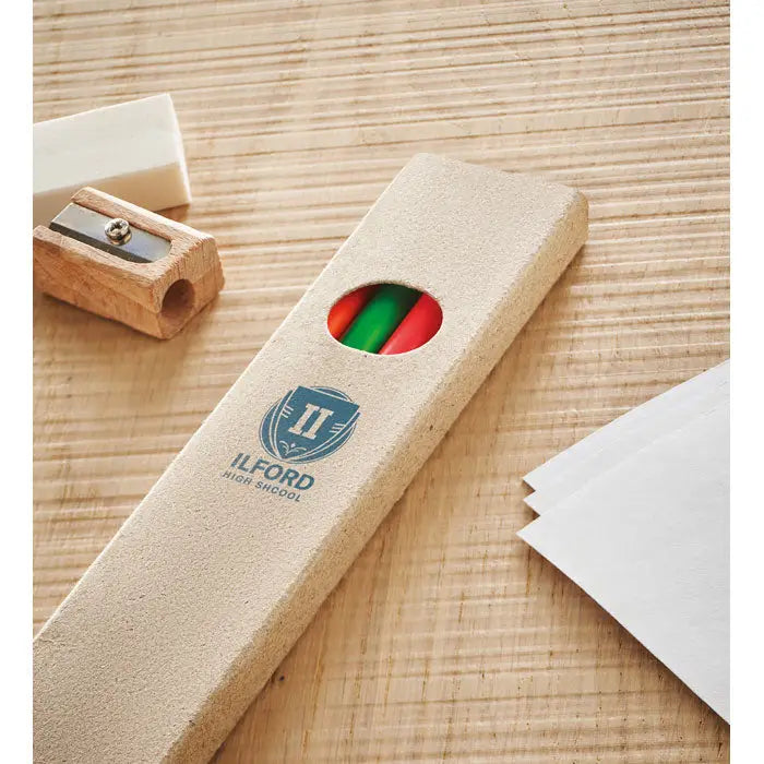 Beige texturat penar cu decupaj circular care arată creioane roșii și verzi și logo ilford high school albastru