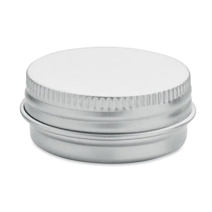 Balsam de buze vegan în cutie rotundă argintie metalică cu capac zimțat și suprafață netedă reflectorizantă