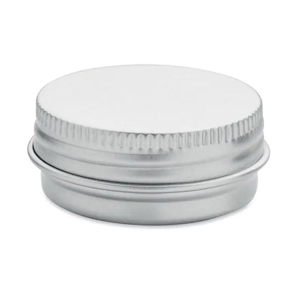 Balsam de buze vegan în cutie rotundă argintie metalică cu capac zimțat și suprafață netedă reflectorizantă