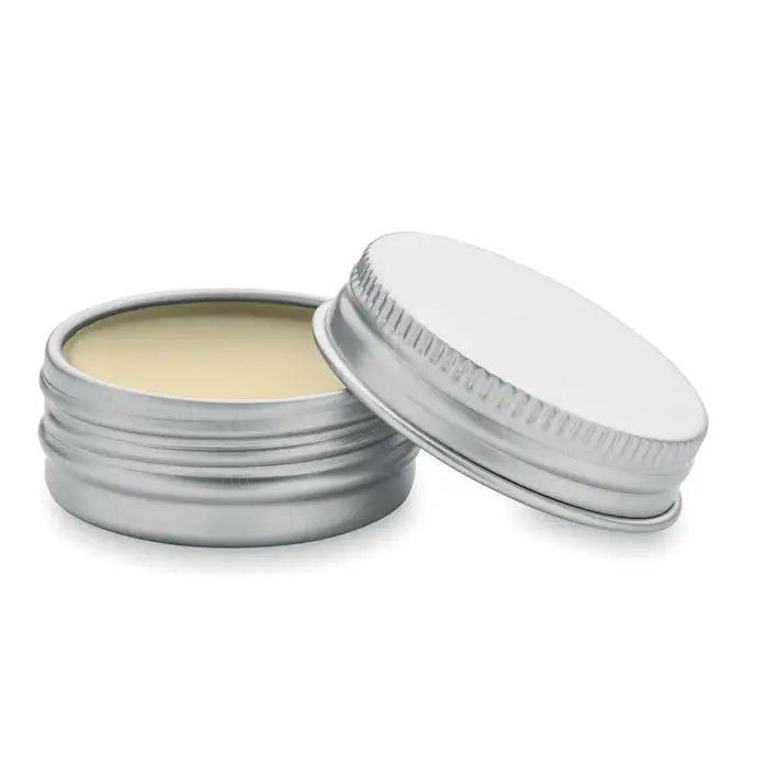 Balsam de buze vegan în cutie rotundă din metal argintiu cu capac zimțat, conținând un balsam galben pal