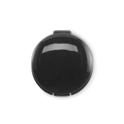 Balsam de buze vegan într-o compactă neagră lucioasă, circulară, cu design minimalist și balama mică sus