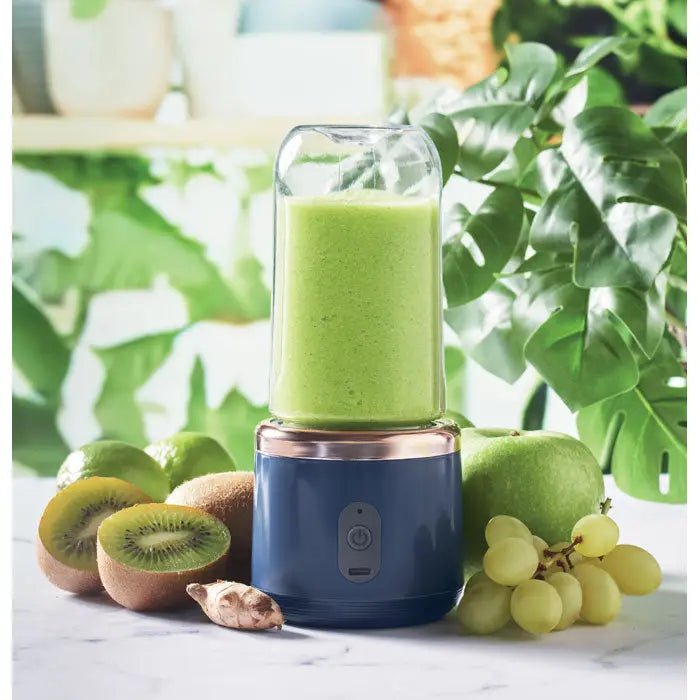 Blender portabil albastru si roz auriu cu recipient de sticla transparent plin cu smoothie verde