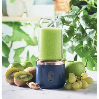 Blender portabil albastru si roz auriu cu recipient de sticla transparent plin cu smoothie verde