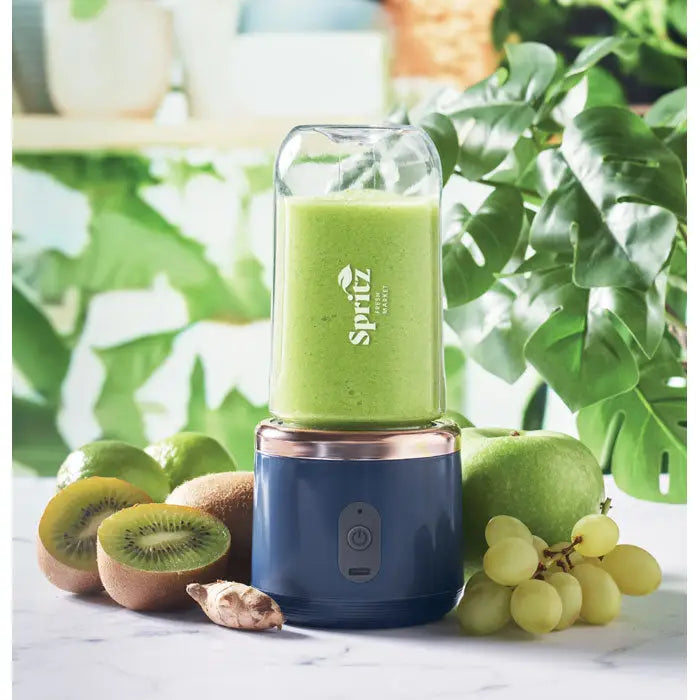 Blender portabil spritz albastru si roz auriu cu vas din sticla transparenta plin cu smoothie verde