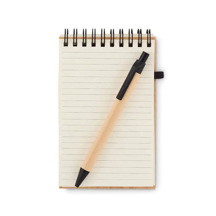 Blocnotes a6 din bambus cu stilou negru elegant si aspect natural asezat pe pagini cu liniaturi spirala