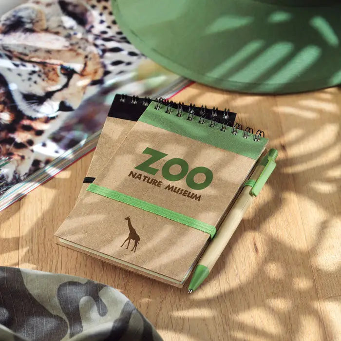 Blocnotes a6 reciclat din hartie kraft maro cu spirala neagra si logo verde zoo nature museum cu girafa