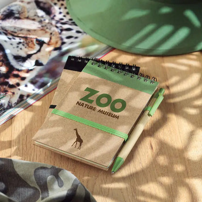 Blocnotes a6 reciclat din hartie kraft maro cu spirala neagra si logo verde zoo nature museum cu girafa