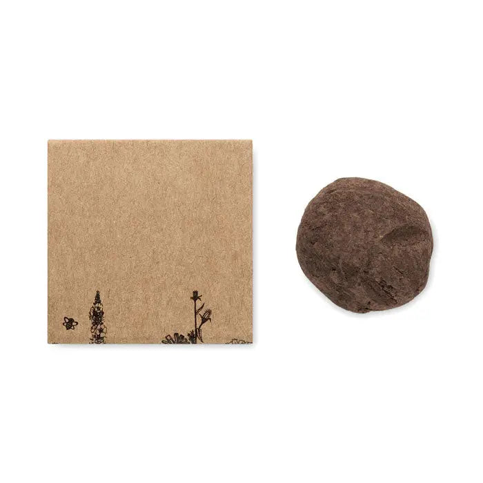 O piatra maro neteda cu textura naturala langa ambalaj kraft decorat cu ilustratii botanice delicate bomba de seminte cu flori de albine