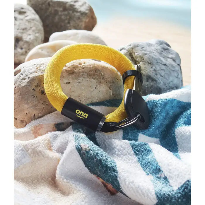 Breloc cu bratara plutitoare din material texturat galben cu carlig din plastic negru si branding ona
