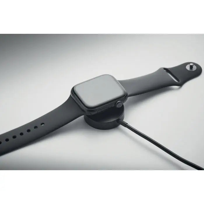 Ceas apple watch negru cu bratara din silicon mat asezat pe suport de incarcare circular pentru breloc cu cablu 4 in 1 de 60w