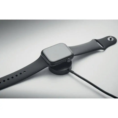 Ceas apple watch negru cu bratara din silicon mat asezat pe suport de incarcare circular pentru breloc cu cablu 4 in 1 de 60w