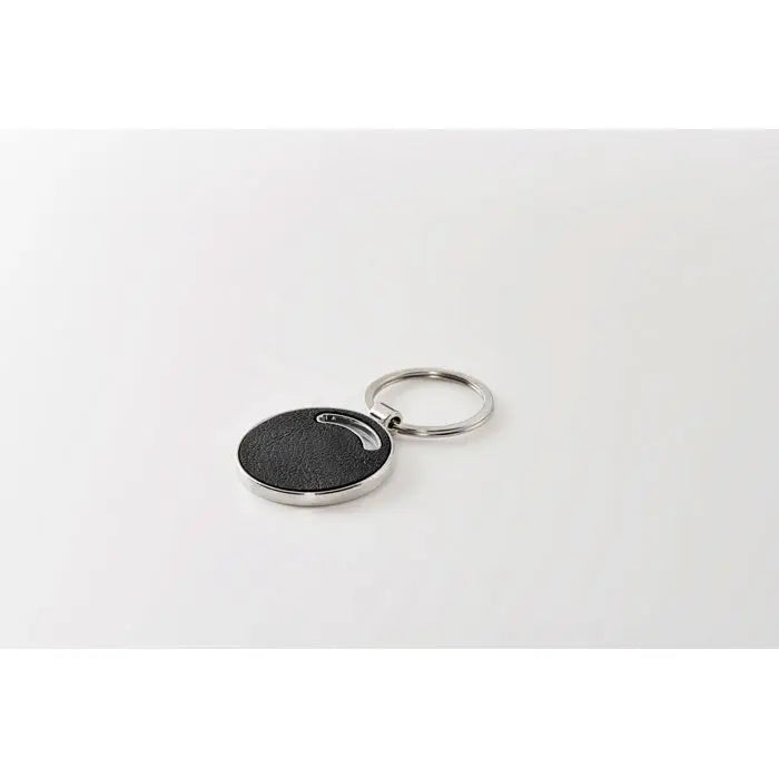 Breloc de forma rotunda negru texturat cu margine metalica argintie si inel pentru chei