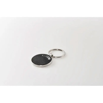 Breloc de forma rotunda negru texturat cu margine metalica argintie si inel pentru chei