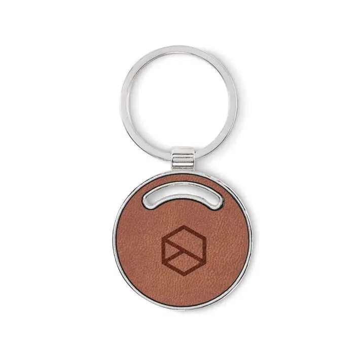 Breloc de forma rotunda din piele maro cu inel metalic argintiu si logo geometric gravat