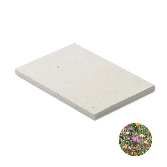 Caiet a5 cu coperta din hartie cu seminte si placă de beton gri deschis cu textura subtila si puncte fine