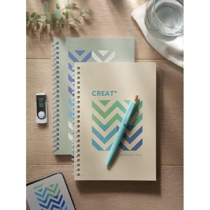 Caiet a5 din carton reciclat cu coperta spiralata bej si model geometric albastru si verde cu logo creat°