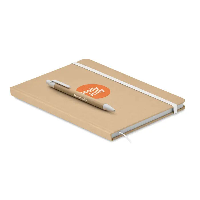 Notebook a5 tan hardcover cu banda elastica alba si pix asortat cu branding holly jolly din carton reciclat