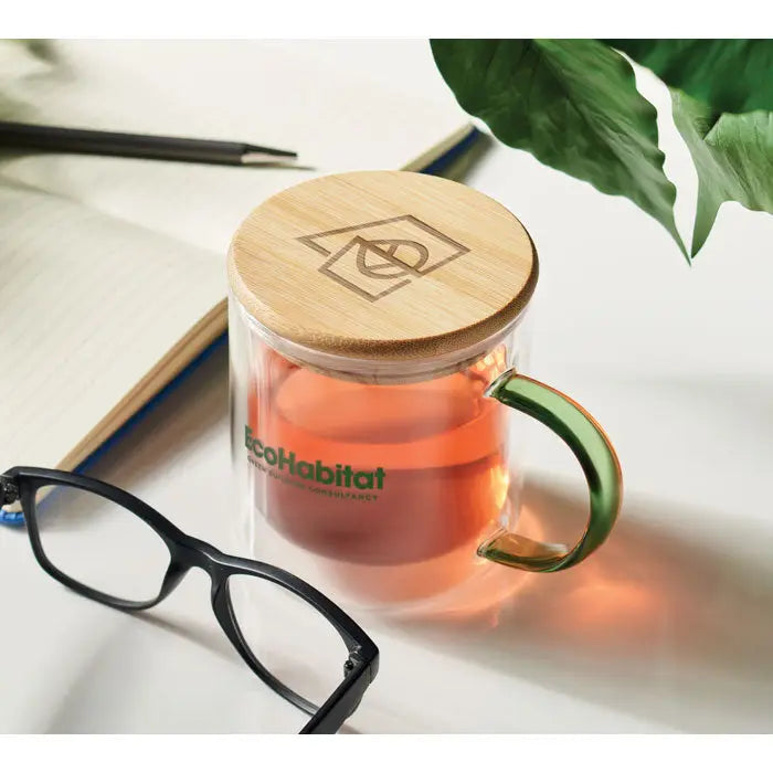 Cana din borosilicat cu perete dublu din sticla transparenta cu maner verde si capac de bambus cu logo ecohabitat verde
