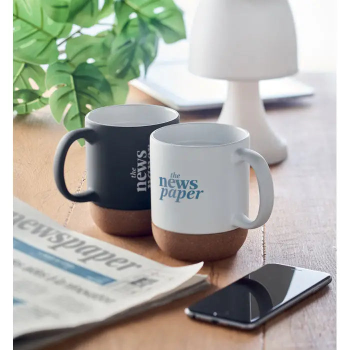 Două căni din ceramică mată de 300 ml cu bază de plută și text the news paper albastru pe exterior negru și alb