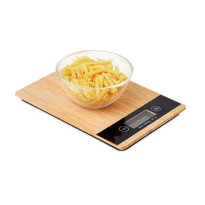 Cantar digital de bucatarie din bambus cu display negru si bol din sticla cu paste penne nefierte pe suprafata