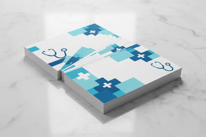 Cărți de vizită premium cu finisaj soft-touch pentru cabinet medical, design CMYK albastru-alb, prezentare evantai pe marmură albă – AndorTipo