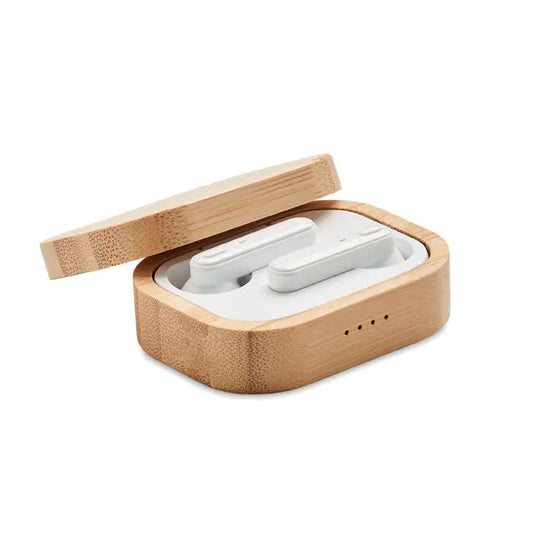 Casti tws albe wireless asezate intr-o carcasa de bambus maro deschis pentru incarcare