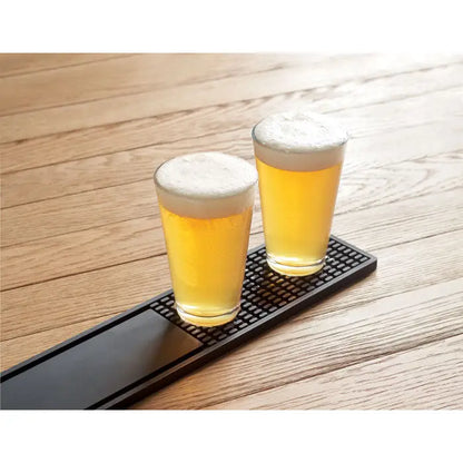 Covoras de bar din pvc negru texturat cu doua pahare de bere aurie asezate pe el