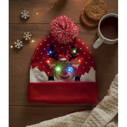 Beanie tricotat craciun rosu cu ren luminat led ochi si coarne si model fulgi de nea plus ciucure roz pufoasă