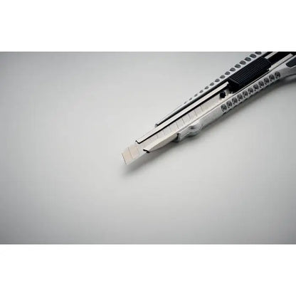 Cutit retractabil din aluminiu cu lama zimtata si maner texturat argintiu si negru
