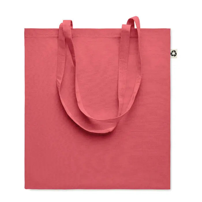 Geanta de cumparaturi din bumbac reciclat coral cu manere din material textil si eticheta mica pe colt