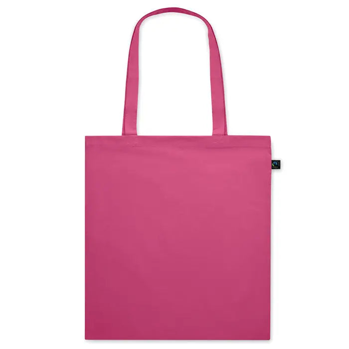 Geanta de cumparaturi fairtrade 140gr/m² din panza fucsia solida cu manere asortate si eticheta neagra mica
