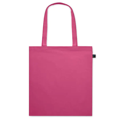 Geanta de cumparaturi fairtrade 140gr/m² din panza fucsia solida cu manere asortate si eticheta neagra mica