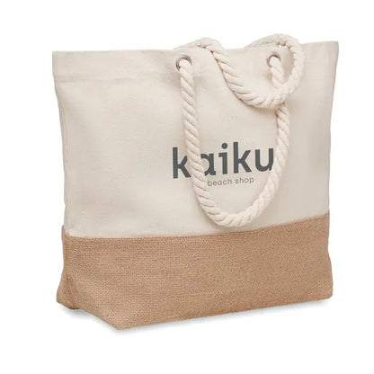 Geanta de plaja din panza bej cu manere din sfoara si fund din iuta cu logo kaiku beach shop