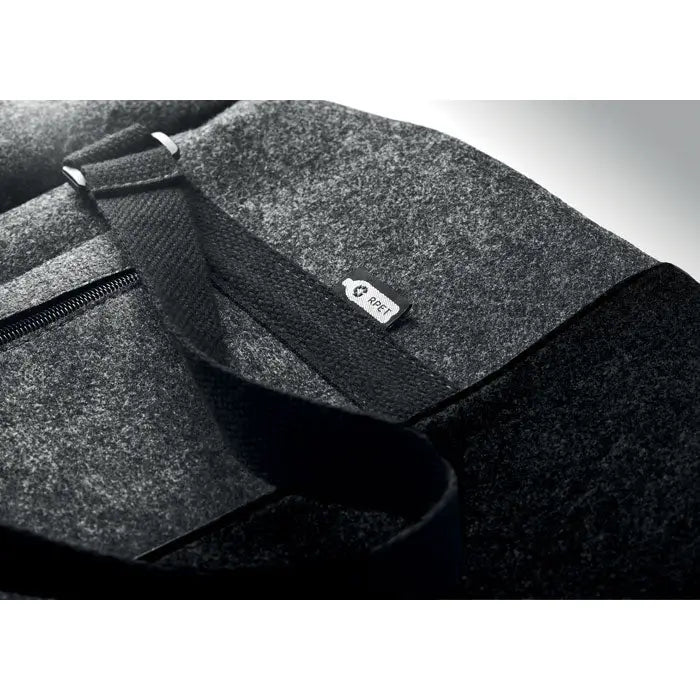 Geanta de weekend din fetru rpet cu bretele negre din material textil si eticheta alba mica visible