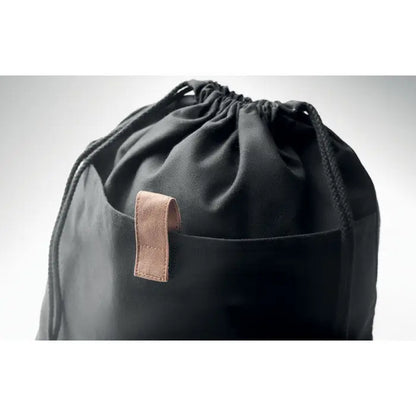 Geanta din bumbac reciclat neagra cu snur si bara de piele maro pe buzunarul frontal