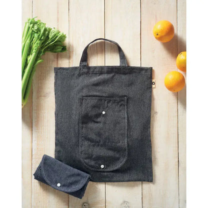 Geanta pliabila pentru cumparaturi din denim gri inchis cu buzunar frontal inchis cu capse albe si versiune compacta rulata