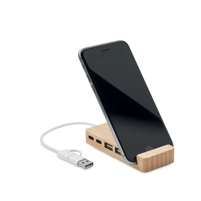 Hub usb bamboo cu 4 porturi suport de telefon din lemn maro deschis cu multiple porturi usb si cablu de incarcare alb lângă