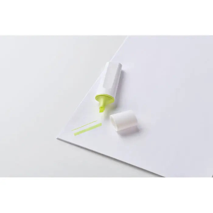 Un marker iluminator rpet alb cu varf si capac verde lime, pe hârtie albă, capac detașat lângă