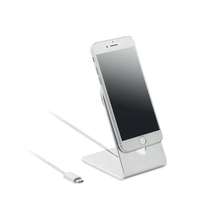Stand telefón mobil portabil argintiu din metal cu design minimalist ținând un iPhone pentru încărcare magnetică 15W
