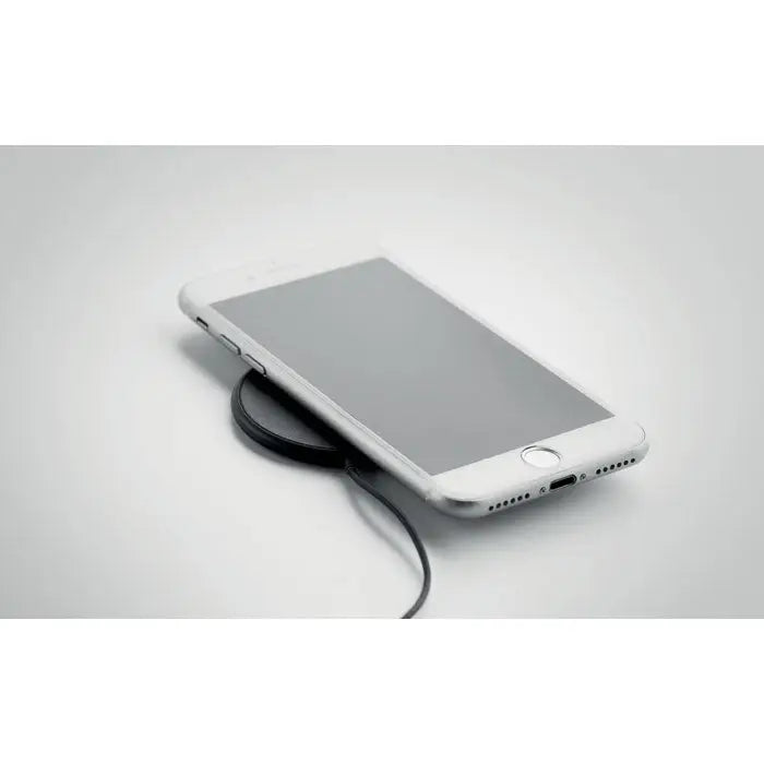 Iphone alb așezat pe un încărcător wireless magnetic negru 10w pentru încărcare rapidă eficientă