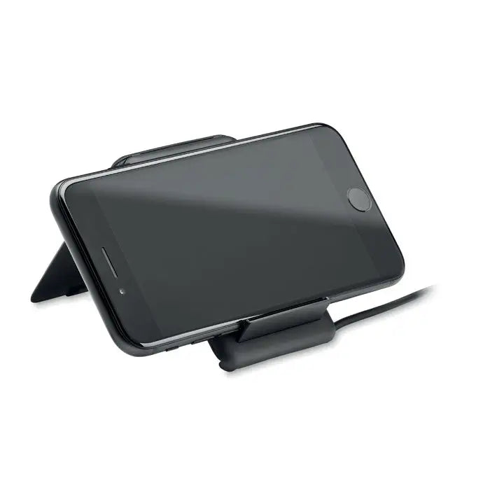 Stand negru pentru smartphone ținând un iPhone negru cu ecranul orientat în sus pentru încărcare wireless 15W