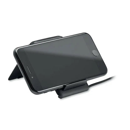 Stand negru pentru smartphone ținând un iPhone negru cu ecranul orientat în sus pentru încărcare wireless 15W