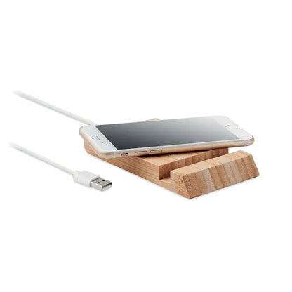Un smartphone auriu elegant pe un suport minimalist de lemn bambus cu textura vizibila si cablu usb alb incarcare wireless 10w